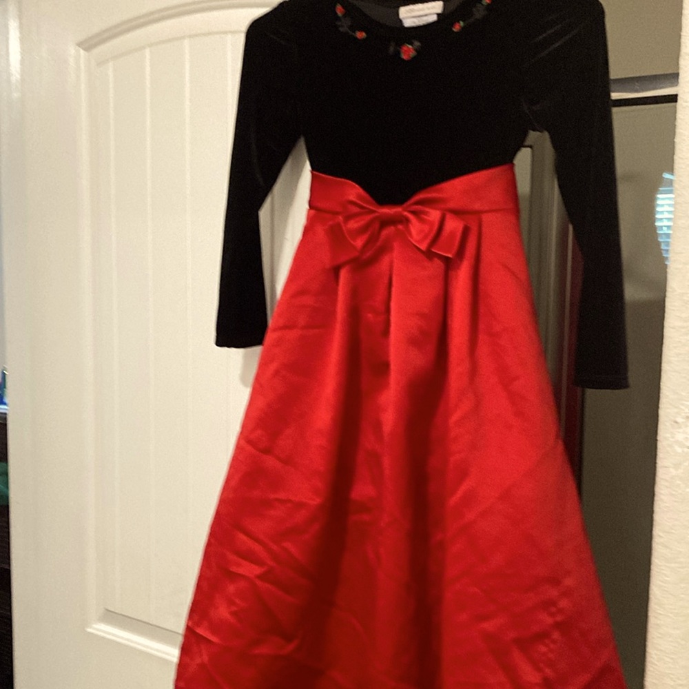 Red and black dress with roses along neck line and bow in front with tie in back